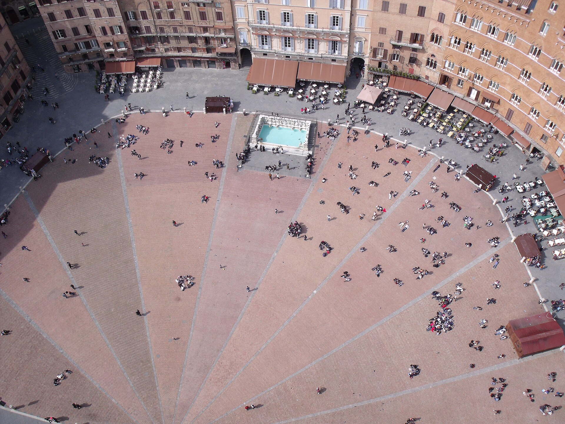 Piazza del Campo vista dalla Torre del Mangia: spicchi di mattone, Fonte Gaia e tavolini.